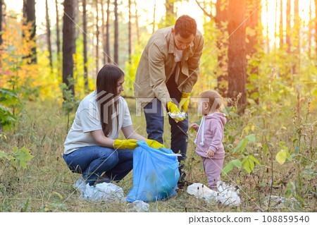 Family helps environment by picking up trash in park 108859540