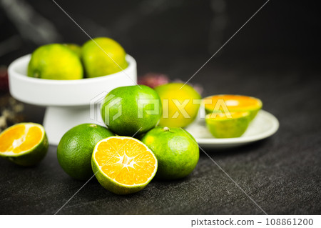 Oranges placed on a black marble slab. 108861200