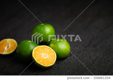 Oranges placed on a black marble slab. 108861204