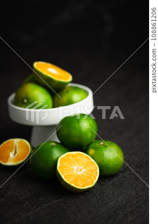 Oranges placed on a black marble slab. 108861206