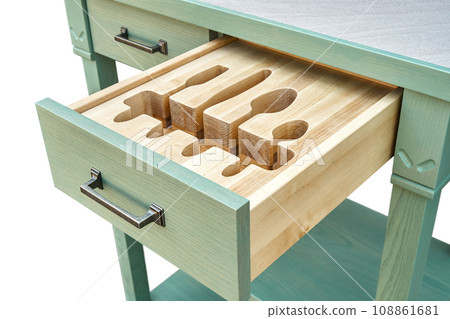 Craved wooden holders for cutlery in serving table drawer 108861681