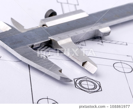 Old metal caliper and engineering drawing. Close up Old metal caliper and engineering drawing. Close up 108861977