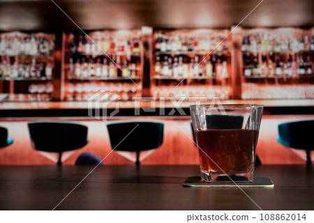Glass of whiskey on the bar in front of the blur image bar Glass of whiskey on the bar in front of the blur image bar 108862014