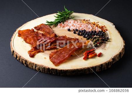 Beef jerky pieces isolated on a white and black background Beef jerky pieces isolated on a white and black background 108862036