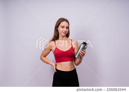 Image of beautiful strong happy cheerful young sports woman posing isolated indoors drinking water. Image of beautiful strong happy cheerful young sports woman posing isolated indoors drinking water. 108862044