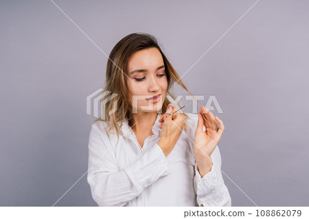 Woman with scissors having hair cut. Amazed female with straight hair, scissor. Haircare concept. Woman with scissors having hair cut. Amazed female with straight hair, scissor. Haircare concept. 108862079