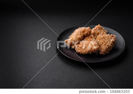 Delicious fresh crispy chicken nuggets on a dark concrete background 108863203