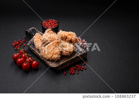Delicious fresh crispy chicken nuggets on a dark concrete background 108863237