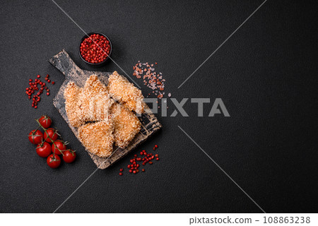Delicious fresh crispy chicken nuggets on a dark concrete background Delicious fresh crispy chicken nuggets on a dark concrete background 108863238