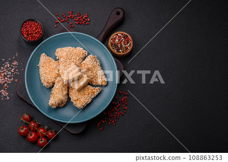 Delicious fresh crispy chicken nuggets on a dark concrete background 108863253