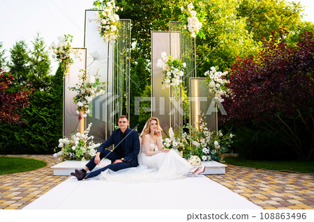 The bride and groom sit on the podium for off-site registration. The bride and groom sit on the podium for off-site registration. 108863496