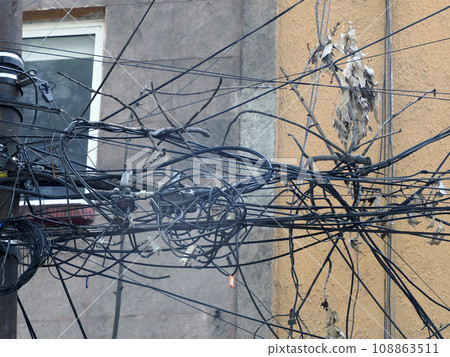 Mexico City Messed up power lines and connection cables. Many tangled wires on electric poles in the city Mexico City Messed up power lines and connection cables. Many tangled wires on electric poles in the city 108863511