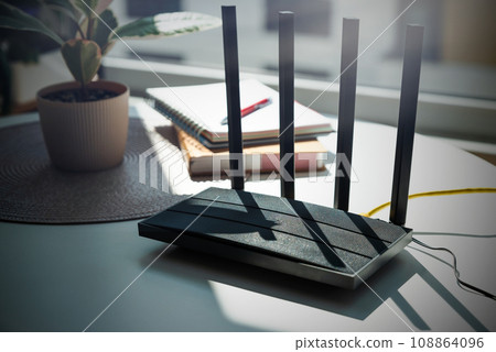 Modern wi-fi router on light table in room Modern wi-fi router on light table in room 108864096