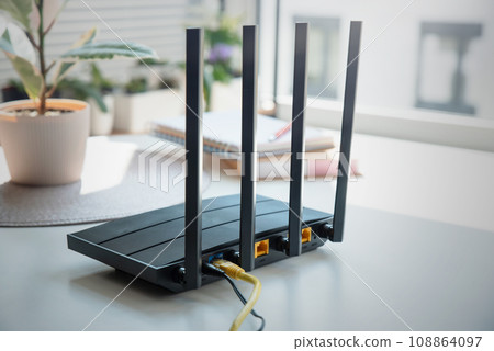 Modern wi-fi router on light table in room Modern wi-fi router on light table in room 108864097