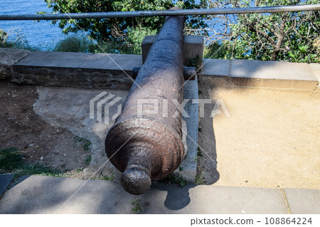 Old cast-iron cannon on the waterfront Old cast-iron cannon on the waterfront 108864224