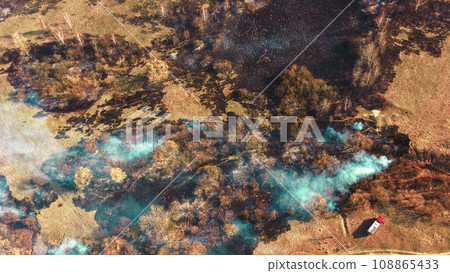 Aerial View. Spring Dry Grass Burns During Drought Hot Weather. Bush Fire And Smoke. Fire Engine, Fire Truck On Firefighting Operation. Wild Open Fire Destroys Grass. Ecological Problem Air Pollution 108865433