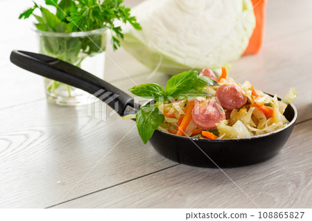 cooked fried cabbage with vegetables and sausages 108865827