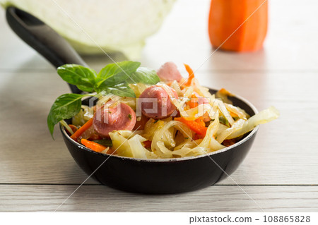 cooked fried cabbage with vegetables and sausages 108865828