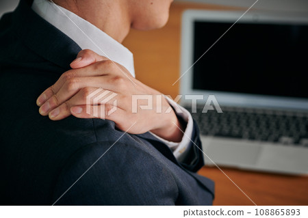 一位因辦公桌工作而肩膀僵硬的年輕男性上班族 108865893