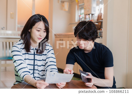 一對年輕夫婦查看賬單詳細信息,發現價格上漲。 一對年輕夫婦查看賬單詳細信息,發現價格上漲。 108866211