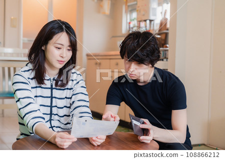 一對年輕夫婦查看賬單詳細信息,發現價格上漲。 一對年輕夫婦查看賬單詳細信息,發現價格上漲。 108866212