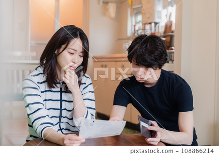 一對年輕夫婦查看賬單詳細信息,發現價格上漲。 一對年輕夫婦查看賬單詳細信息,發現價格上漲。 108866214