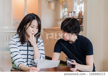 一對年輕夫婦查看賬單詳細信息,發現價格上漲。 一對年輕夫婦查看賬單詳細信息,發現價格上漲。 108866215