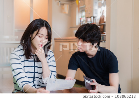 一對年輕夫婦查看賬單詳細信息,發現價格上漲。 一對年輕夫婦查看賬單詳細信息,發現價格上漲。 108866218