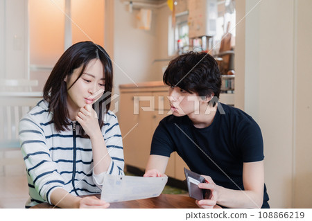 一對年輕夫婦查看賬單詳細信息,發現價格上漲。 一對年輕夫婦查看賬單詳細信息,發現價格上漲。 108866219
