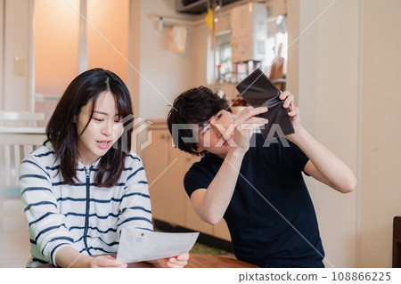一對年輕夫婦查看賬單詳細信息,發現價格上漲。 一對年輕夫婦查看賬單詳細信息,發現價格上漲。 108866225