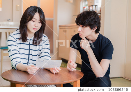 一對年輕夫婦查看賬單詳細信息,發現價格上漲。 一對年輕夫婦查看賬單詳細信息,發現價格上漲。 108866246