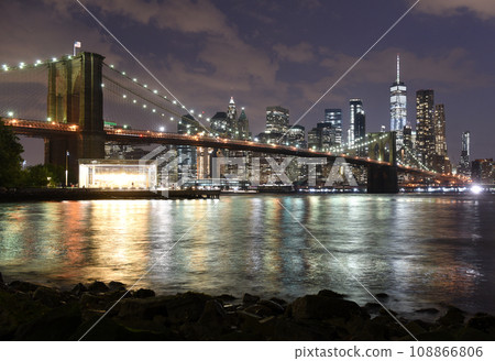 New York City, financial district in lower Manhattan with Brooklin Bridge at night, USA 108866806