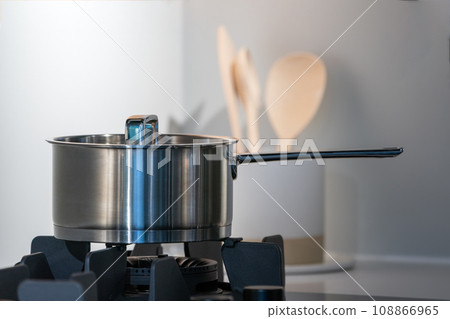 stainless steel pot on electronic modern flat stove in low light on counter kitchen room stainless steel pot on electronic modern flat stove in low light on counter kitchen room 108866965