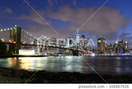 New York City, financial district in lower Manhattan with Brooklin Bridge at night, USA 108867026
