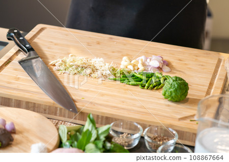 Thai spicies ,lemon grass, garlic, shallot, bergamot and paprika, were prepared to cook by chopped on cutting board. Thai spicies ,lemon grass, garlic, shallot, bergamot and paprika, were prepared to cook by chopped on cutting board. 108867664