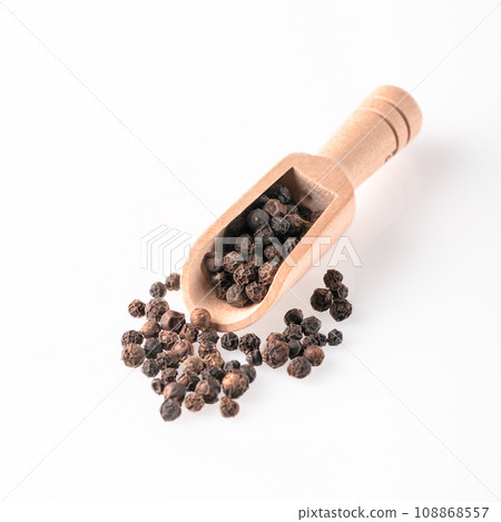 Peppercorns lie in a wooden scoop. 108868557