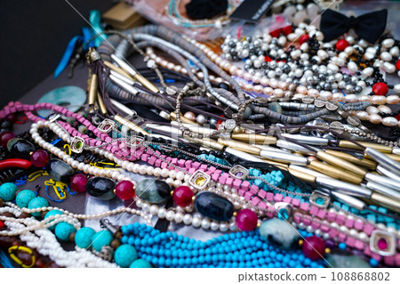 Necklaces made of beads of various colors, shapes, and materials are lining the shelves. Even though the composition is different, it creates a more positive appearance. 108868802