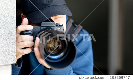 A man holding a camera 108869747