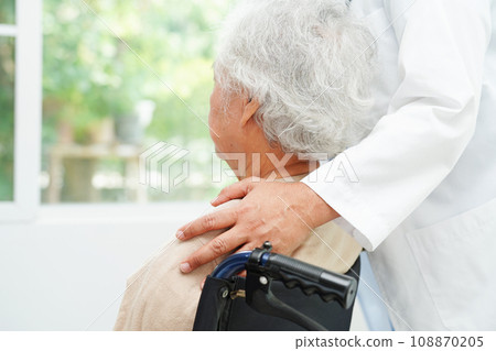 Doctor help Asian elderly woman disability patient sitting on wheelchair in hospital, medical concept. Doctor help Asian elderly woman disability patient sitting on wheelchair in hospital, medical concept. 108870205