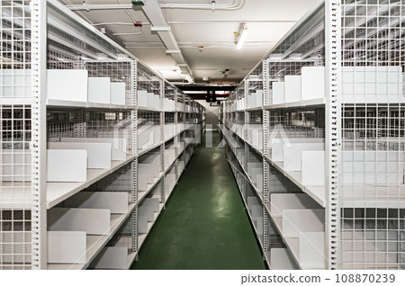 White shelves are lined up all over the area in a warehouse with a green floor. It also has an excellent security system. White shelves are lined up all over the area in a warehouse with a green floor. It also has an excellent security system. 108870239