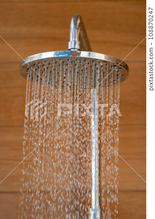 Close up to Outdoor shower head for the bath and showering cold water to body before jumping in the resort pool. Close up to Outdoor shower head for the bath and showering cold water to body before jumping in the resort pool. 108870247
