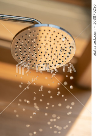 Close up to Outdoor shower head for the bath and showering cold water to body before jumping in the resort pool. 108870250
