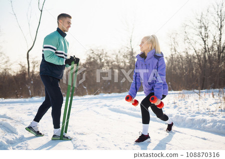 Young couple winter morning exercise at snowy forest. Healthy fitness lifestyle. Sport, Active life. 108870316
