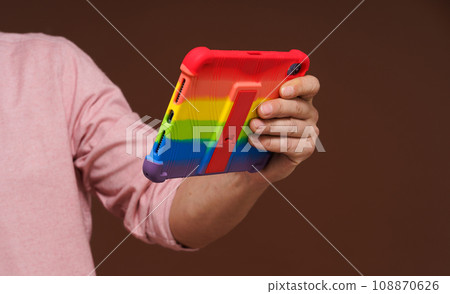 Sign of gay culture and LGBTQ pride representing man's hand holding pocket PC adorned in rainbow colors, Rainbow symbolism reflects diversity and inclusivity of LGBTQ community. High quality photo Sign of gay culture and LGBTQ pride representing man's hand holding pocket PC adorned in rainbow colors, Rainbow symbolism reflects diversity and inclusivity of LGBTQ community. High quality photo 108870626