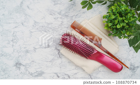 Comb (hairbrush) and towel white marble background Comb (hairbrush) and towel white marble background 108870734