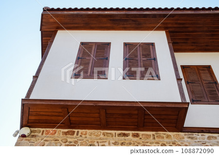 Ancient house with wooden shutters on the windows 108872090
