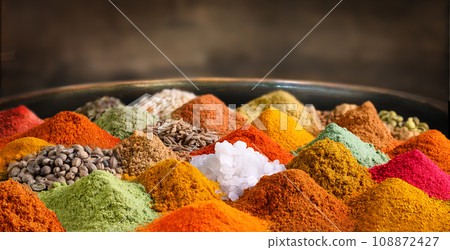 Different spices and seasonings on dark rustic background 108872427