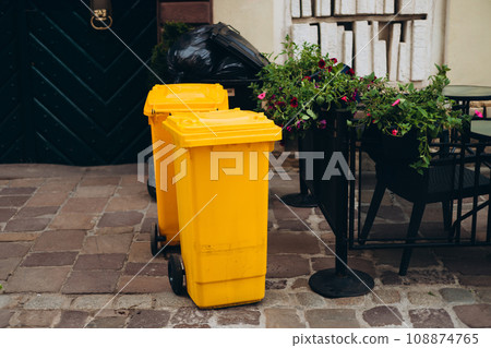 Yellow recycling cans out on the street for pick up. Trash recycle. Bin container for disposal garbage waste and save environment. Yellow dustbin for recycle plastic trash 108874765