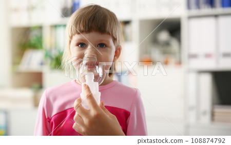 Little girl breathing with inhaler at doctor office 108874792
