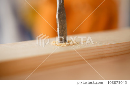 Flat drill bit make hole in wooden bar 108875043
